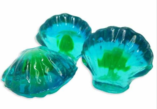 Three shell-shaped blue and green gummies on a white background