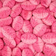 Close-up of pink oval candies with 'Milk' text on a pink background