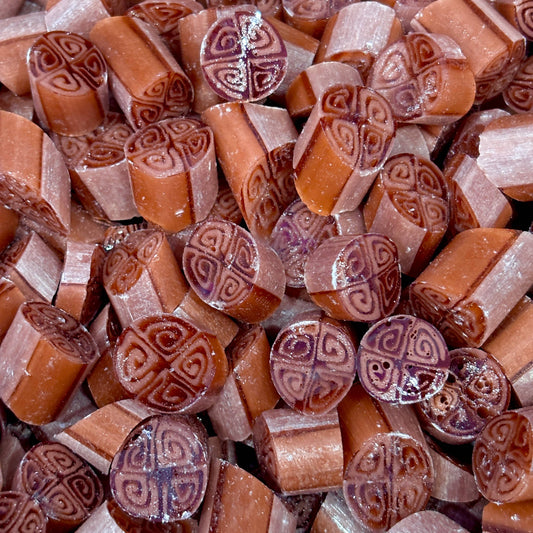 Close-up of hard candy with intricate designs on a pile