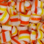 Close-up of candy corn with red, yellow, and white stripes.